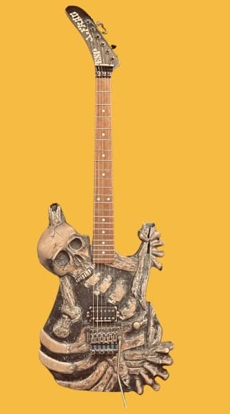 Guitar with a body carved into a skeletal skull and bones design, replicating George Lynch's "Mom" guitar.
